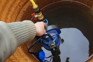 Бочковой насос погружают в емкость для организации выкачки воды Бочковой насос погружают в емкость для организации выкачки воды